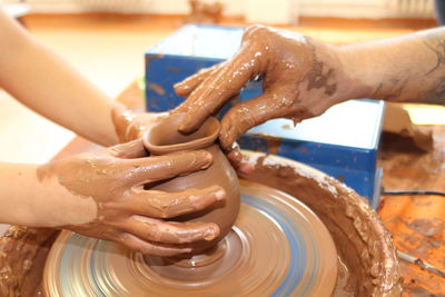 Cropped image of hands making pottery