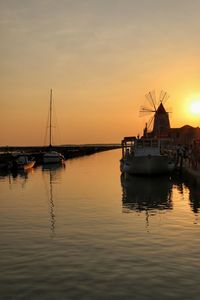 Boats in sea at sunset