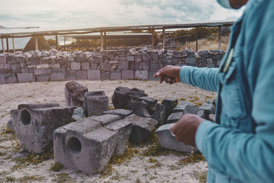 Rear view of man standing by logs