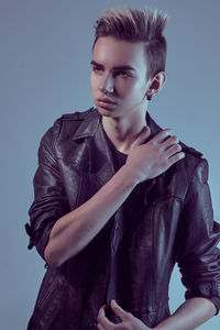 Young man against standing gray background