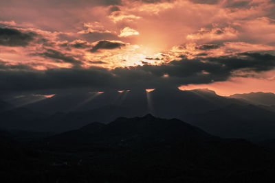 Scenic view of silhouette mountains against sky at sunset