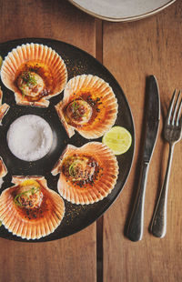 Scallops with flamed shells on a black plate. luxury restaurant food. seafood, selective focus.