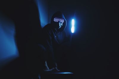 Man with illuminated light painting in darkroom