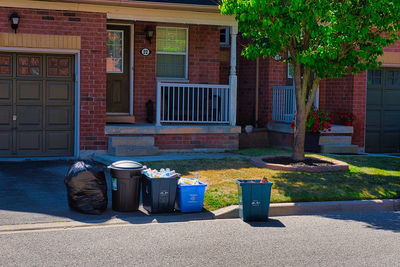 Garbage bin on sidewalk against building in city