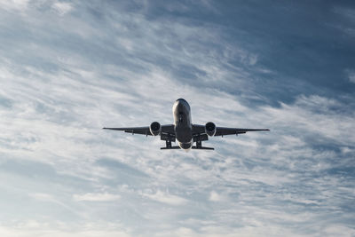 Low angle view of airplane flying against sky