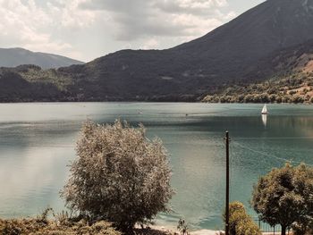 Scenic view of lake by mountains against sky