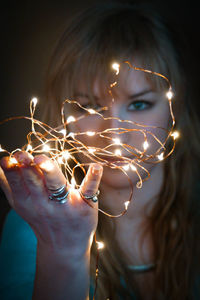 Close-up of illuminated lighting equipment against black background
