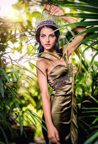 Portrait of young woman against tree