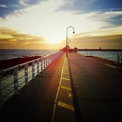 Pier on sea at sunset