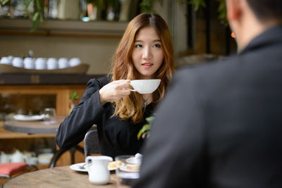 Young woman drinking coffee in cafe