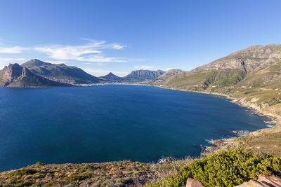 Scenic view of sea and mountains against blue sky