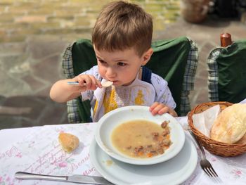 High angle view of boy eating breakfast at table