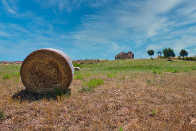 Hay bales on field against sky