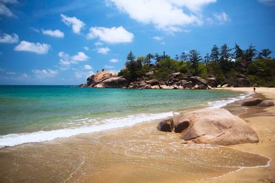 Scenic view of rocks on beach against sky