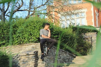 Portrait of woman sitting on bench in park