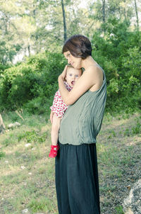 Young couple kissing against trees