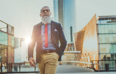 Portrait of a man standing against buildings in city