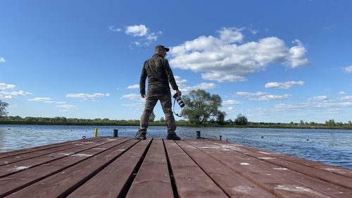 Full length of man standing on pier over sea against sky