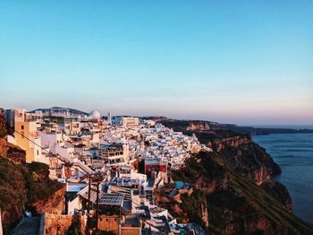 High angle view of townscape by sea against clear sky