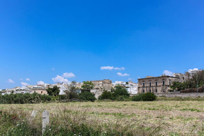 Old building on field against blue sky