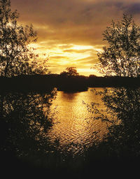 Scenic view of lake against orange sky