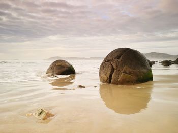 Rocks on sea shore against sky