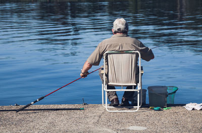 Rear view of man fishing in lake