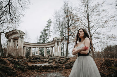 Full length of woman standing by bare trees
