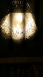 Low angle view of illuminated pendant lights hanging from ceiling