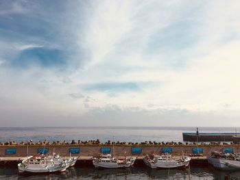 Boats moored in sea against sky