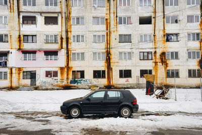 Cars on snow covered buildings in city