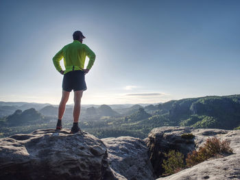 Runner workout outdoor in rocks during trail marathon on mountain path. sunny lens flares