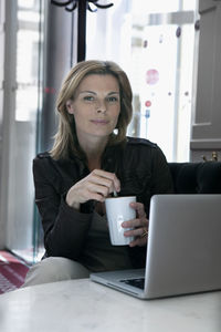 Businesswoman sitting in office with mug