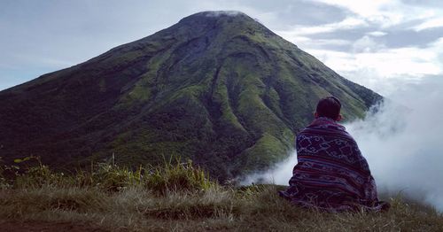 Rear view of man on mountain against sky