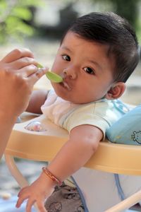 Cropped hand of mother feeding son