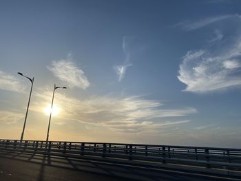 Street by sea against sky during sunset