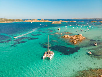 High angle view of sailboats in sea against clear sky