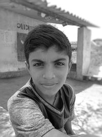 Portrait of boy against house in village