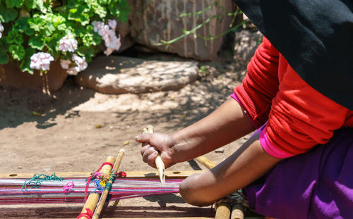 Midsection of woman making craft on field