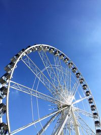 Low angle view of ferris wheel against blue sky