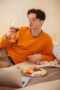 Midsection of man drinking glasses on table