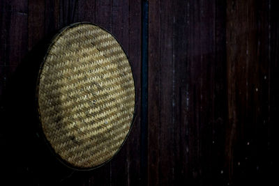 Close-up of hat hanging on wooden wall