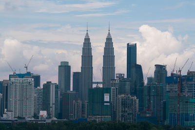 Buildings in city against cloudy sky