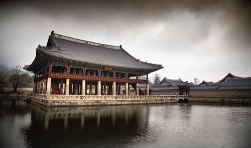 Building by lake against sky