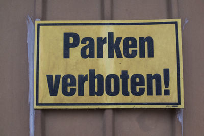 Close-up of warning sign on corrugated iron