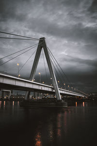 Bridge over river against sky in city