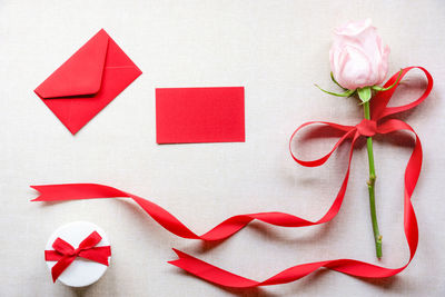 Close-up of rose and gift on table