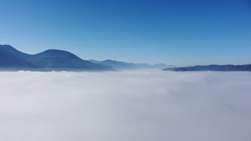 Scenic view of mountains against blue sky