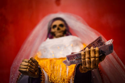 Skeleton in bride costume holding money