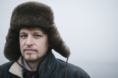 Portrait of young man in fur hat during winter